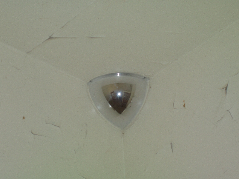 A seclusion room's security mirror on the ceiling.